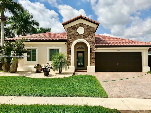 1010 NE 36th Ave, Homestead, FL 33033 - mediterranean / spanish-style home with a tiled roof, a garage, stone siding, and stucco siding
