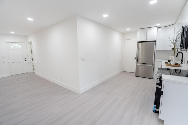 3531 NW 26th St, Lauderdale Lakes, FL 33311 - kitchen featuring freestanding refrigerator, light countertops, recessed lighting, light wood-type flooring, and white cabinets