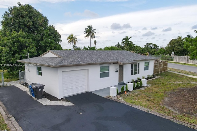 3531 NW 26th St, Lauderdale Lakes, FL 33311 - ranch-style home featuring fence, stucco siding, roof with shingles, and driveway
