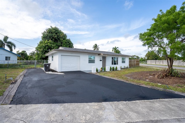 3531 NW 26th St, Lauderdale Lakes, FL 33311 - view of front of property with a garage, stucco siding, fence, and driveway