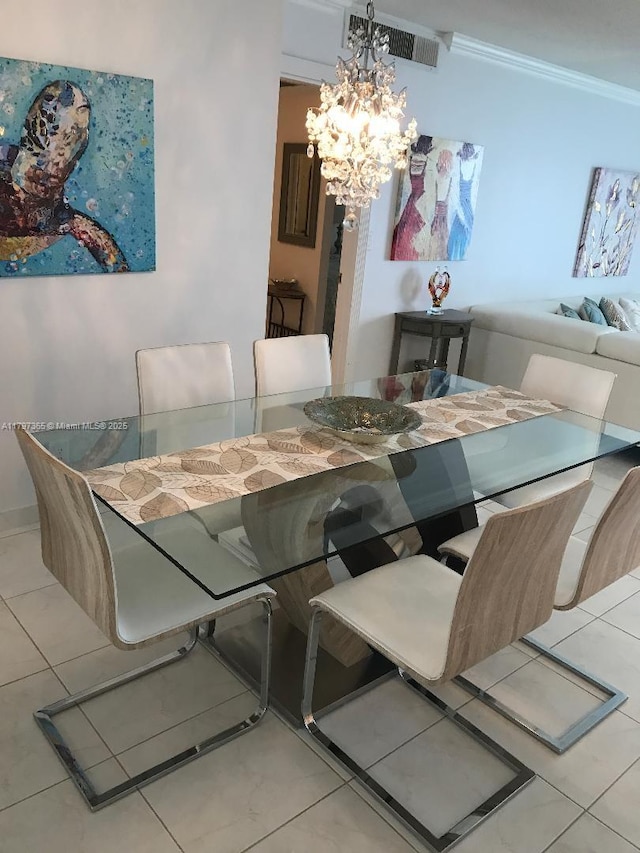 dining space featuring a chandelier, ornamental molding, and tile patterned flooring