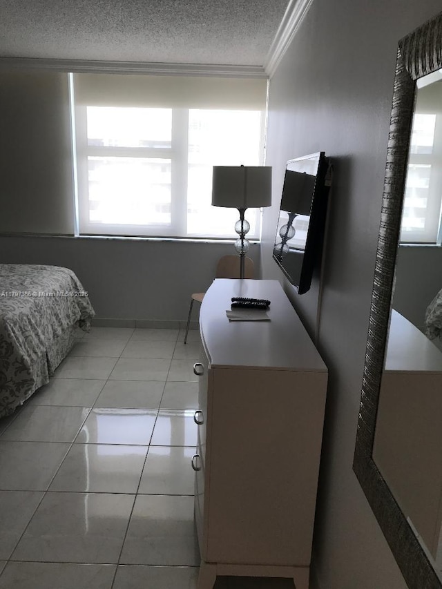 bedroom featuring a textured ceiling, ornamental molding, and light tile patterned floors
