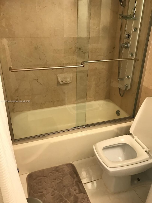 bathroom with bath / shower combo with glass door and toilet