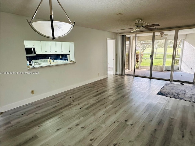 9501 Seagrape Dr Unit 101, Davie, FL 33324 - unfurnished living room featuring a ceiling fan, wood finished floors, baseboards, and a textured ceiling