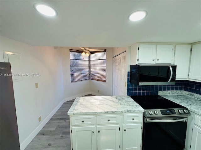 kitchen featuring black microwave, stainless steel range with electric cooktop, ceiling fan, tasteful backsplash, and light wood-type flooring