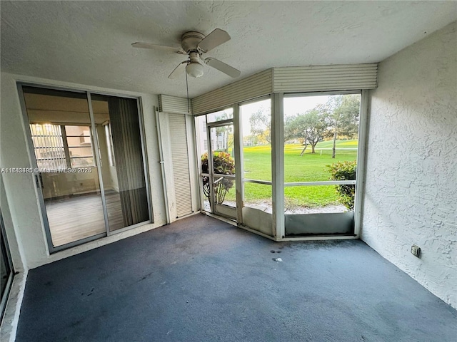 unfurnished sunroom with ceiling fan