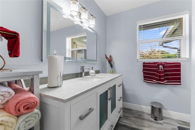 bathroom featuring wood finished floors, baseboards, and vanity