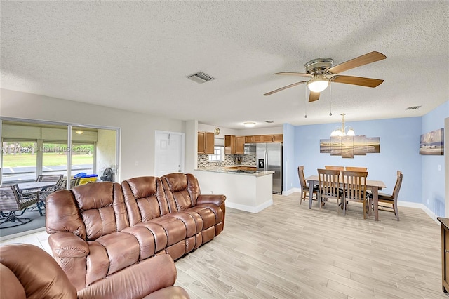 14030 Nesting Way Unit D, Delray Beach, FL 33484 - living area with a ceiling fan, a textured ceiling, light wood finished floors, and a chandelier