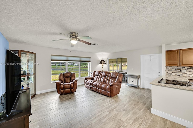 14030 Nesting Way Unit D, Delray Beach, FL 33484 - living room with ceiling fan, light wood-style floors, and a textured ceiling