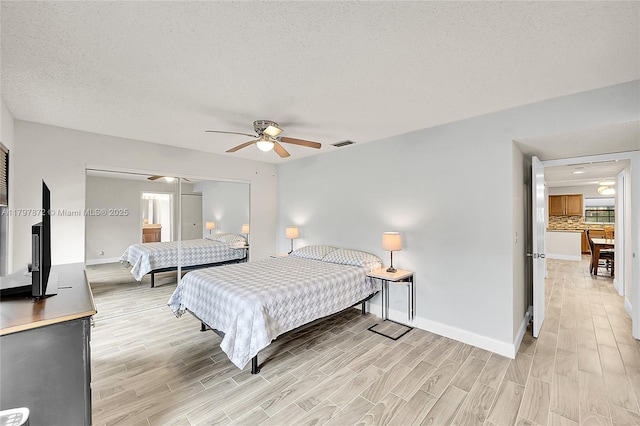 14030 Nesting Way Unit D, Delray Beach, FL 33484 - bedroom featuring light wood-type flooring, a ceiling fan, a textured ceiling, and multiple windows