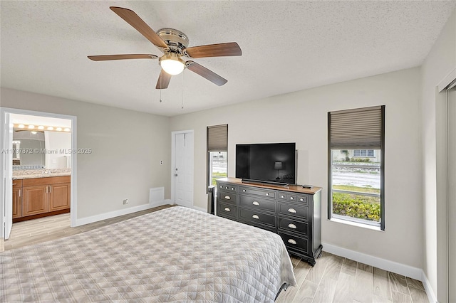 14030 Nesting Way Unit D, Delray Beach, FL 33484 - bedroom with a textured ceiling, light wood-type flooring, ensuite bathroom, and ceiling fan