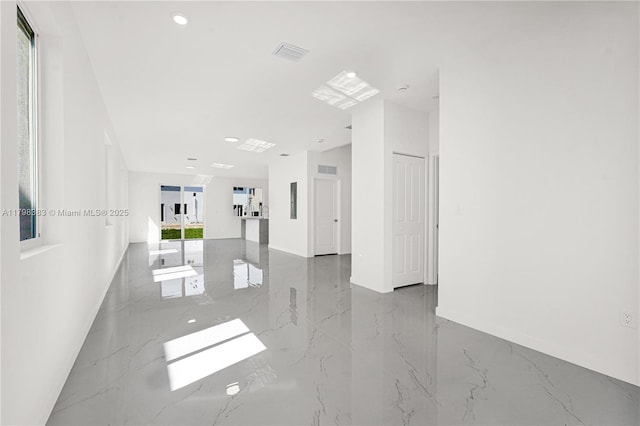 empty room featuring marble tiled floors, recessed lighting, and baseboards