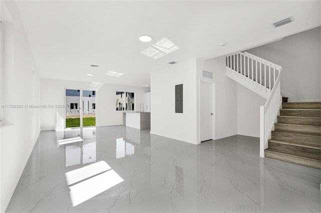 spare room featuring marble tiled floors, electric panel, stairs, and recessed lighting