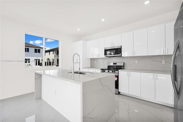 kitchen featuring appliances with stainless steel finishes, a sink, light marble finish flooring, recessed lighting, and decorative backsplash