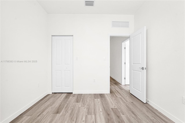 unfurnished bedroom with light wood-style flooring and baseboards