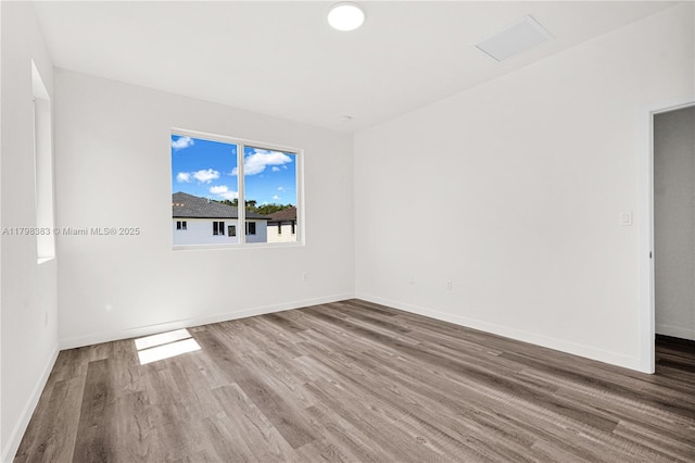 unfurnished room with wood finished floors and baseboards
