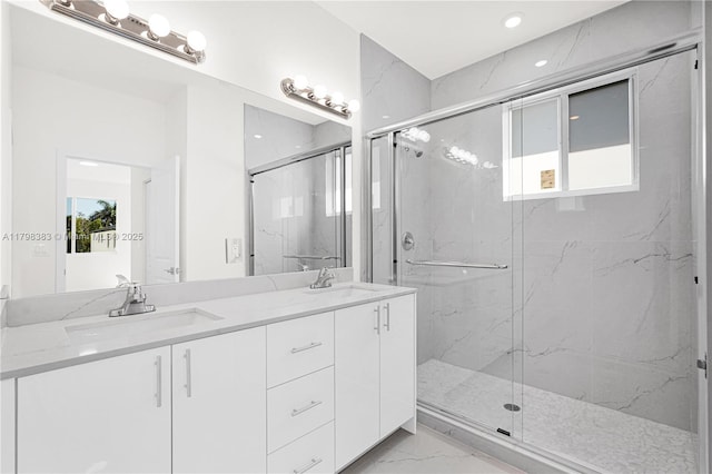 full bathroom with marble look tiles, a marble finish shower, double vanity, and recessed lighting