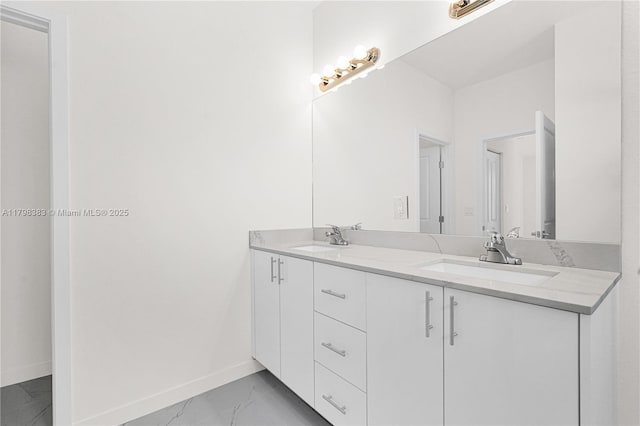 bathroom with baseboards, double vanity, and marble look tile flooring