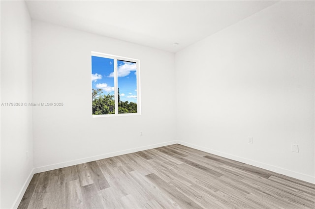 spare room featuring light wood-style floors and baseboards