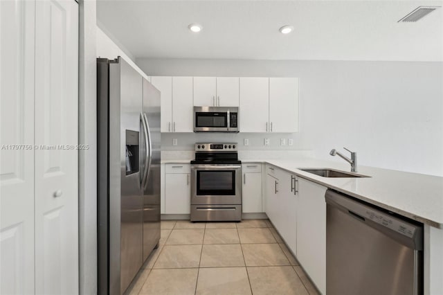 28625 SW 132nd Ct, Homestead, FL 33033 - kitchen with stainless steel appliances, a sink, light countertops, white cabinetry, and light tile patterned floors