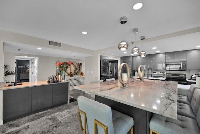 kitchen with stainless steel appliances, modern cabinets, gray cabinets, a breakfast bar area, and recessed lighting