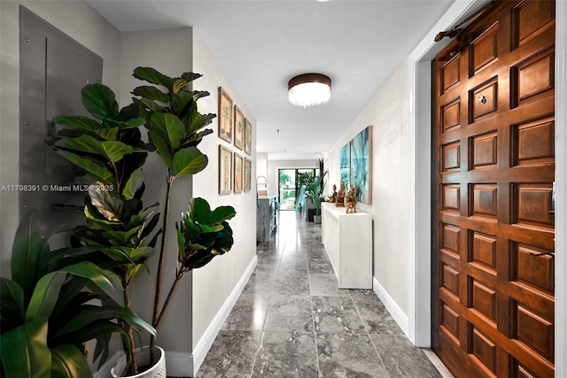 hallway with baseboards and stone finish flooring