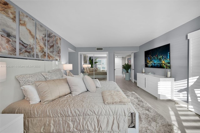 bedroom with wood finished floors and two closets