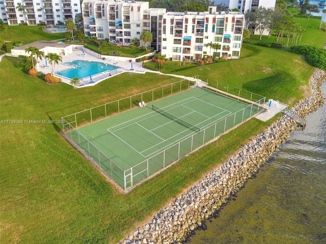 drone / aerial view of apartment complex, a pool, and a large body of water
