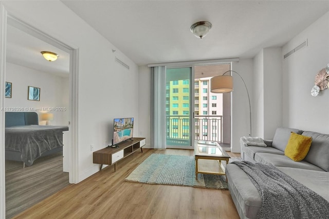 living area featuring expansive windows, wood finished floors, and baseboards