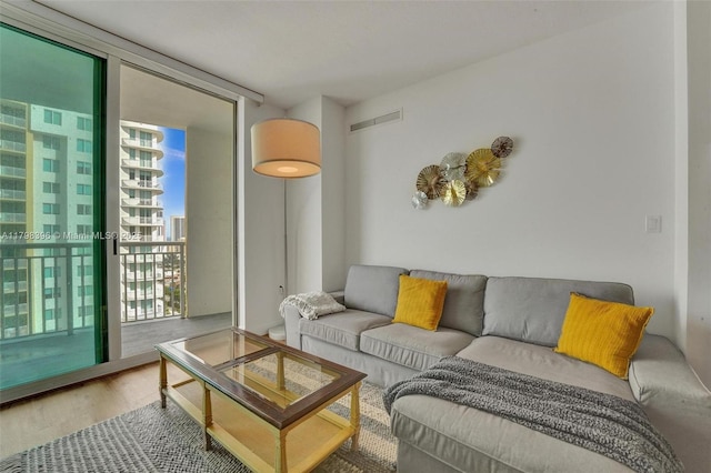 living area with a wall of windows and wood finished floors