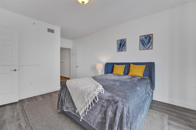 bedroom with wood finished floors and baseboards