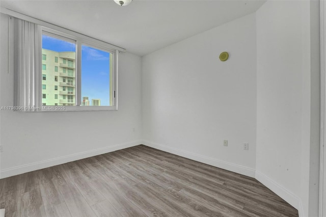 unfurnished room featuring wood finished floors and baseboards