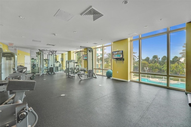 exercise room featuring floor to ceiling windows and baseboards