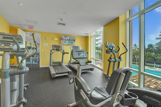 exercise room with floor to ceiling windows, baseboards, and recessed lighting