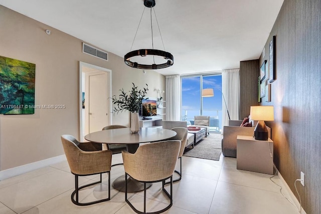 dining space with light tile patterned floors, baseboards, and a chandelier