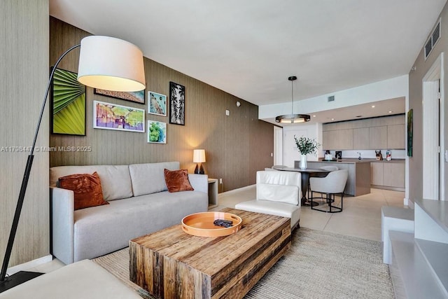 living area featuring light tile patterned floors and wooden walls