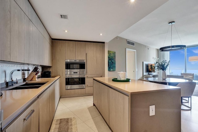 kitchen featuring a sink, stainless steel double oven, modern cabinets, a center island, and recessed lighting