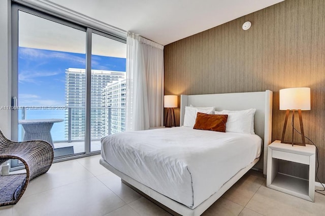 bedroom featuring access to exterior, light tile patterned flooring, and floor to ceiling windows