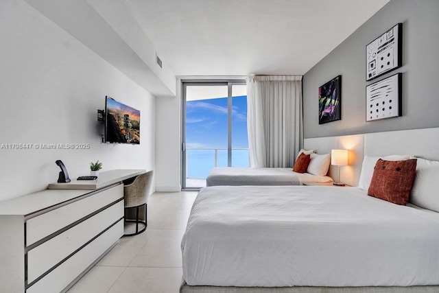 bedroom with access to outside, light tile patterned flooring, and a wall of windows