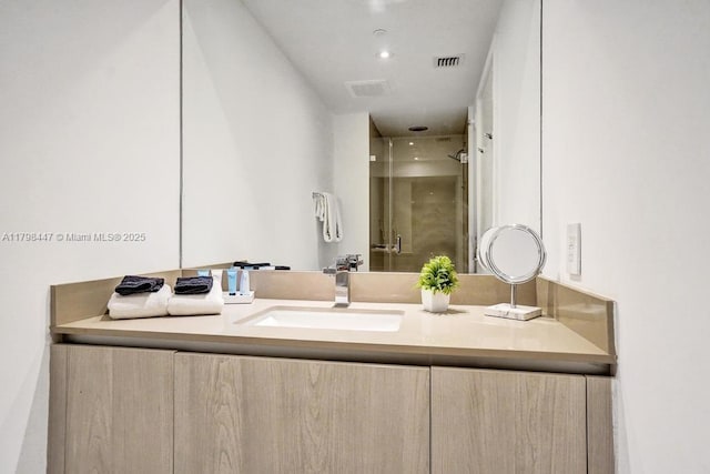 bathroom with a shower stall and vanity