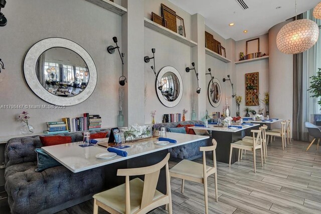 dining area featuring a towering ceiling and wood finished floors