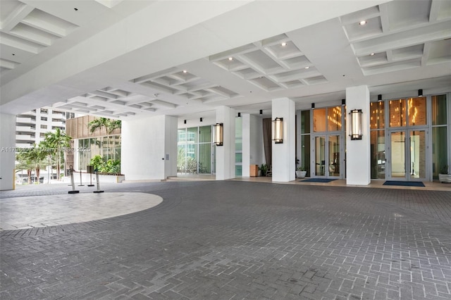building lobby featuring coffered ceiling and beamed ceiling
