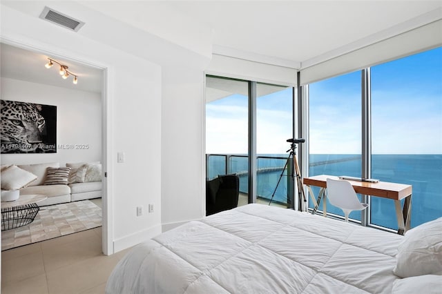 bedroom featuring tile patterned flooring, baseboards, and a water view