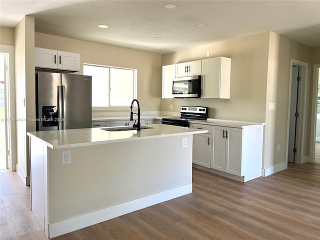 1300 Waite Dr, Fort Myers, FL 33903 - kitchen featuring stainless steel appliances, a sink, light wood finished floors, recessed lighting, and light countertops