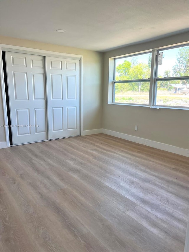 1300 Waite Dr, Fort Myers, FL 33903 - unfurnished bedroom featuring baseboards, a closet, and wood finished floors