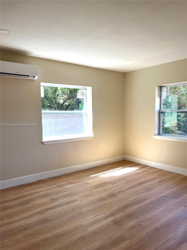 1300 Waite Dr, Fort Myers, FL 33903 - unfurnished room featuring a wall mounted AC, plenty of natural light, baseboards, and wood finished floors
