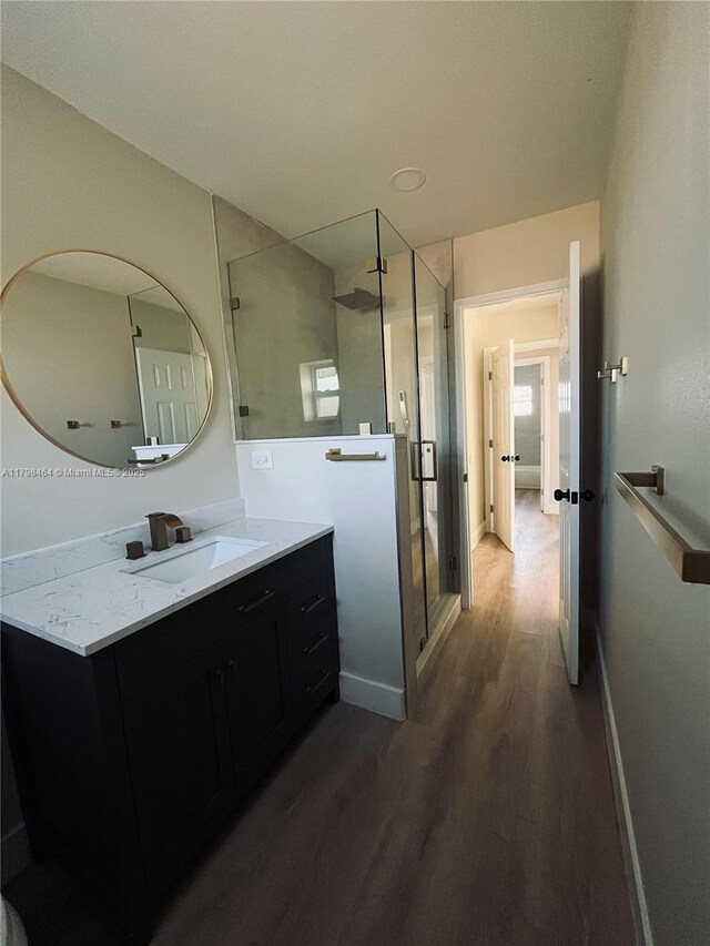 1300 Waite Dr, Fort Myers, FL 33903 - bathroom featuring wood finished floors, vanity, a stall shower, and baseboards