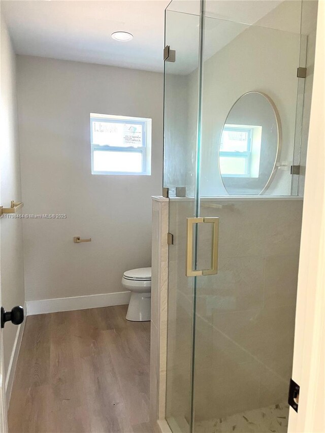 1300 Waite Dr, Fort Myers, FL 33903 - bathroom with toilet, a shower stall, wood finished floors, and baseboards