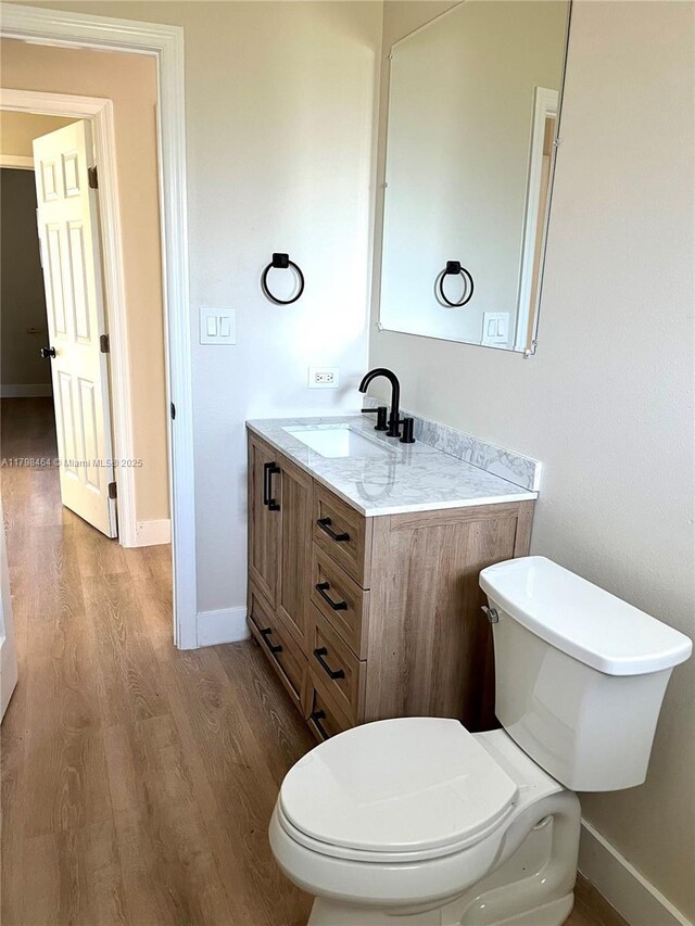 1300 Waite Dr, Fort Myers, FL 33903 - bathroom featuring wood finished floors, toilet, baseboards, and vanity