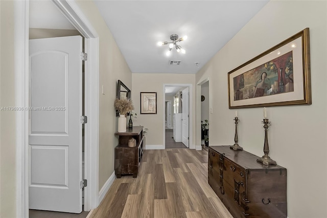 2221 N 46th Ave, Hollywood, FL 33021 - corridor with wood finished floors, baseboards, and a chandelier